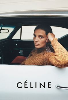 a woman sitting in the back seat of a car with her hand on her head