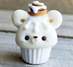 there is a small white cupcake shaped like a bear