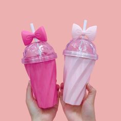 two plastic cups with bows and straws on them are shown in front of each other