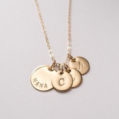 "Gold filled Nana necklace personalized with initials. A sweet and simple gift for grandma, that she will truly cherish. Personalized with grandchildren's initials. Dainty, timeless, perfect for every day. FEATURES: * high-quality gold filled discs are hand finished, * the large disc is carefully hand stamped with the word \"NANA\", * small discs will be stamped with initials of your choice, * delicate gold filled chain is finished with a spring clasp closure. MEASUREMENTS: * 14K gold filled lar Classic Necklaces For Mother's Day Personalized Gift, Everyday Personalized Initial Pendant Necklace, Customizable Initial Pendant Charm Necklace For Mom, Classic Personalized Initial Necklace For Mother's Day, Classic Personalized Jewelry For Mother's Day, Classic Name Charm Necklaces For Mother's Day, Personalized Initial Pendant Charm Necklace For Mom, Classic Charm Necklaces For Mother's Day Personalized Gift, Classic Personalized Name Charm Necklaces