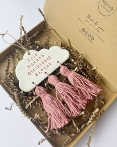 two pink tassels in a box with the words happy mother's day on it