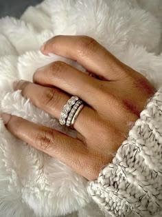 a woman's hand with two rings on top of her finger and the other ring is