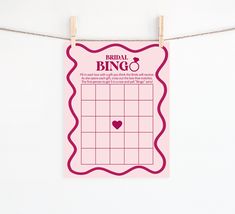 a pink bridal bingo game hanging on a rope with clothes pins attached to it