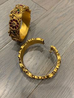 Temple bangle in matte gold and ruby stone. Detailing has the Rajasthani similarity. About an inch wide. Disclaimer: Price listed is for a single Kada. If you want to get them in a pair please select quantity 2. Gold Bangle Cuff Bracelet For Festivals, Gold Metal Temple Jewelry Bracelets, Gold Metal Temple Jewelry Bracelet, Gold Ruby Bracelet In Temple Jewelry Style, Gold Ruby Bracelets In Temple Jewelry Style, Gold Jeweled Bangle For Festivals, Gold Temple Jewelry Cuff Bracelet For Wedding, Festive Brass Bangle Bracelets, Gold Jeweled Bracelets For Festivals