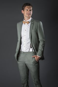 a man in a suit and bow tie posing for the camera with his hands on his hips