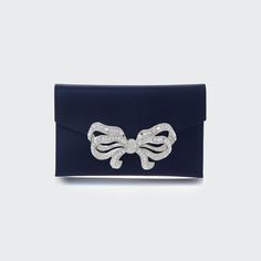 Judith Leiber Couture satin clutch bag with crystal-embellished bow accent. Detachable shoulder strap, 18.9" drop. Envelope flap with snap closure. Interior, satin lining; one slip pocket. 5"H x 8.5"W x 0.5"D. Imported. Elegant Wedding Bags With Bow Detail, Elegant Wedding Bags With Bow, Elegant Clutch Bag With Bow, Elegant Bags With Bow For Party, Elegant Bags With Bow For Events, Rectangular Bag With Bow For Events, Elegant Party Bag With Bow, Elegant Party Bags With Bow Detail, Rectangular Event Bag With Bow Detail