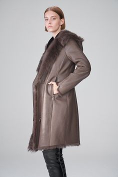 Women's Shearling Leather Trench Coat In Dark Brown Elevate your winter wardrobe with our women's shearling leather trench coat in Dark Brown. Crafted from genuine sheepskin leather with a semi-aniline finish, shop trench leather coat features a cozy faux shearling inner shell. The hooded fur collar adds a touch of sophistication and warmth, while the zipper closure ensures a snug fit. Designed with open hem cuffs, one inside pocket, and two side zip pockets, this dark brown trench coat offers both style and functionality, making it a perfect choice for cold weather. Outer Shell: Genuine Leather Leather Type: Sheepskin Leather Finish: Semi-aniline Inner Shell: Faux Shearling Feature: Hooded Fur Collar Closure Style: Zipper Collar Style: Hooded Cuffs Style: Open Hem Inside Pockets: One Outs Mink Colored Leather Outerwear With Faux Fur Trim, Luxury Long Mink Coat, Luxury Mink Long Coat, Classic Sheepskin Coat With Faux Fur Trim, Classic Sheepskin Fur Coat With Faux Fur Trim, Luxury Sheepskin Outerwear In Mink Color, Luxury Mink Shearling Fur Coat, Sheepskin Long Coat In Mink Color, Long Sheepskin Coat In Mink Color