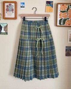 Step back in time with this adorable pleated wrap skirt, inspired by the classic charm of the 1950s. Made from 100% vintage wool, this skirt is both cozy and stylish, perfect for adding a retro flair to your wardrobe. The playful double bow closure adds a cute, eye-catching detail, while the pleated design gives it a flattering shape and flow. Whether you're dressing up for a special occasion or adding a vintage touch to your everyday look, this skirt is a fun and fashionable statement piece you'll love to wear. Key Features: - 100% wool shell - Partial satin lining - Hook closure at waistband - Cotton ties at the front princess seam Size:  - waist 24" - hips 36" - length 27.75" Pendleton Skirt Outfit, Vintage Pleated Skirt Outfit, Vintage Wool Lined Skirt, Spring Wool Pleated Skirt, Retro Wool Skirt For Winter, Vintage Pleated Skirt For Winter, Retro Fitted Cotton Pleated Skirt, Vintage Accordion Pleats Skirt For Fall, Retro Green Pleated Skirt