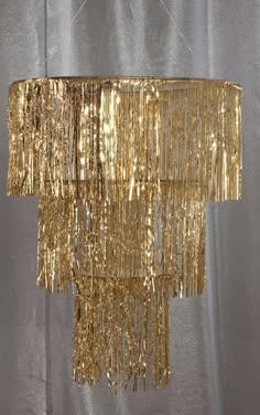 a gold chandelier hanging from the ceiling in a room with silver walls and curtains