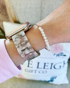 a woman's arm with two bracelets on it and a watch on her wrist