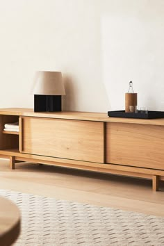 a living room with a large wooden entertainment center and lamp on top of the tv stand