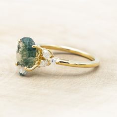 a close up of a ring with a green and white stone on it's side