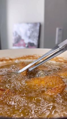 a large pot filled with food and a spatula sticking out of it's side