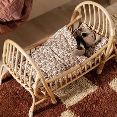 a baby crib with a teddy bear in it next to a brown and white checkered rug