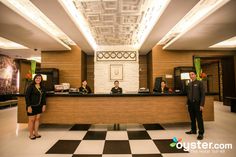 two people standing at the front desk of a hotel