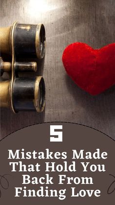 a red heart sitting on top of a metal table next to two spools