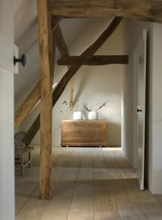 a room with white walls and wooden beams