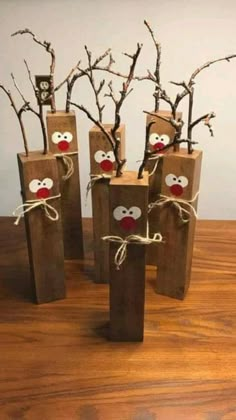 four wooden sticks with faces and noses tied to them, sitting on top of a table