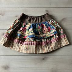 Matilda Jane Floral Apron Skirt. Pull on brown plaid design too with floral patterns and stripes at the bottom of skirt. Size 2 years, 80% cotton, 38 % nylon and 2 % spandex. Excellent used condition. Brown Patchwork Tiered Skirt, Bohemian Brown Cotton Skirt, Fitted Brown Cotton Skirt, Spring Brown Patchwork Skirt, Cotton Skirted Bottoms With Patchwork, Cotton Tiered Skirt With Floral Patchwork, Multicolor Cotton Ruffled Skirt, Brown Cotton Gathered Skirt Bottoms, Brown Cotton Bottoms With Gathered Skirt