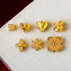 five different types of gold jewelry on a white cloth