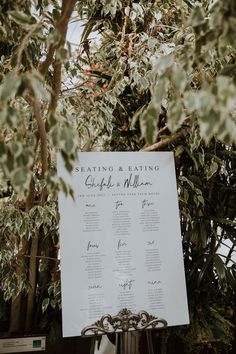 an outdoor seating plan is displayed on a metal stand with greenery in the background