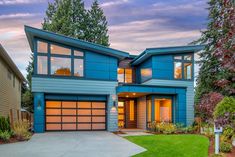 a large blue house with lots of windows on the front and side of it's roof