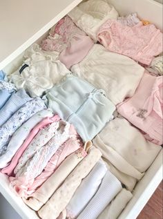 a drawer filled with lots of baby clothes