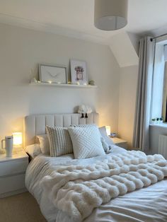 a white bed with pillows and blankets on it