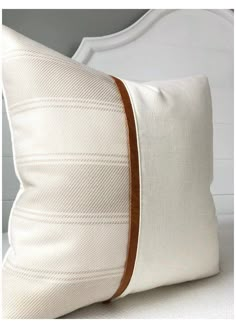 a close up of a pillow on a bed with a white headboard and foot board