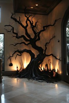 a room with a large tree and candles on the floor