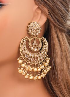 These Polki earrings are a classic addition to any traditional outfit with their stunning stones, crystals, and pearls. They add an exquisite charm and make for the perfect accessory to complete your look. Earrings length: Approx. 3.5" Weight of each earring: 31 gms Push-Back Closure. Antique Gold Plated on high-quality brass as the base metal In-stock & ready-to-ship Color may vary slightly due to light condition & photography. Jewelry Care: Keep away from moisture. Allow perfumes and lotion to Gold Crystal Earrings, Onam Earrings, Earing Designs Gold For Wedding, Chandbali Earrings Gold Antiques, Golden Earrings Indian, Ear Rings Gold Indian, Kashmir Jewellery, Big Earrings Indian, Kashmir Outfits