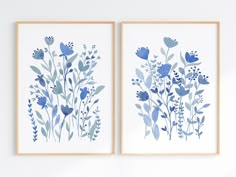 two blue flowers are on the wall next to each other, and one is framed in wood