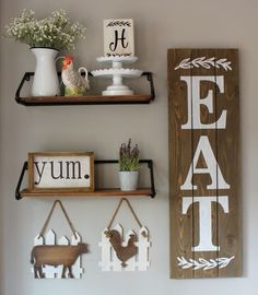 two wooden signs are hanging on the wall next to some shelves with pictures and other items