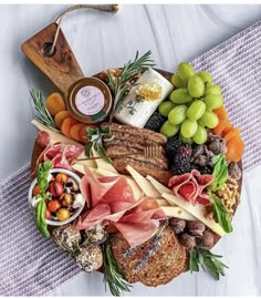 a platter filled with meats, cheeses and fruit