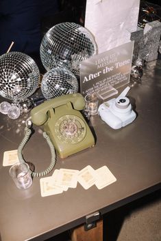 a table topped with disco balls and an old style phone on top of it's side