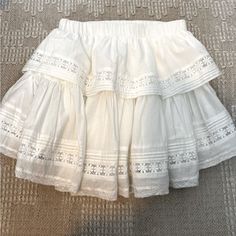 White Layered Mini Skirt With Lace Detail. Skirt Is Slightly Longer In Back And Features An Elastic Waist Band To Easily Accommodate Sizing. Perfect For A Concert Or Back To School! Skirt Has Never Been Worn, Smoke Free Home. Layered Mini Skirts, White Skirt Ruffle, White Layered Skirt Outfit, Chic Skirt With Lace Trim For Vacation, Chic Lace Trim Skirt For Vacation, Flowy Skirt With Lace Trim For Vacation, Chic Vacation Skirt With Lace Trim, Flowy Lace Trim Skirt For Vacation, Vacation Flowy Skirt With Lace Trim