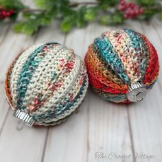 two crocheted balls sitting next to each other on top of a wooden table