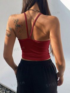 the back of a woman's red tank top with tattoos on her upper half