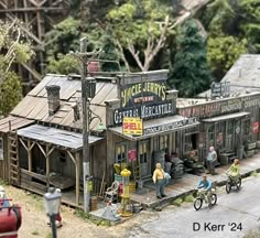 a miniature model of a gas station with people on bikes and motorcycles parked in front of it