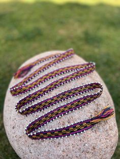 a rock with some beads on top of it and grass in the backround