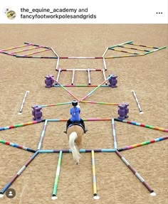 a person riding a horse in front of an obstacle course made out of plastic barrels