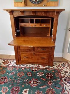 a wooden desk with a clock above it on top of a rug in front of a wall