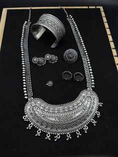 Add charm and Charisma to your beautiful personality with this exquisitely designed and handcrafted German Silver and oxidised necklace and earrings combo set. pair it with any casual semi formal or informal attire and gather compliments for unique and classy choice ideal wear for both casual and dressy occasions This set includes big necklace , small chain with pendant, pair of earrings, ring,  nose pin and bracelet. Amazing quality Ring Nose Pin, Informal Attire, Earrings Combo, Oxidised Necklace, Beautiful Personality, Chain With Pendant, Big Necklace, Oxidized Necklace, Nose Pin