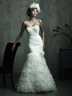 a woman in a white dress standing next to a chair