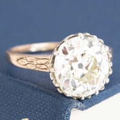 A gorgeous old mine cut diamond ring in the 4ct range sitting in her OG two-tone mounting with the sweetest details! She's a 4.32ct GIA N color and SI1 clarity with a much brighter, cleaner face-up than the grading expresses. The stone sits in a buttercup style setting with charming swoopy details and an engraved floral motif on each of the shoulders. We absolutely love this ring - perfect for those maximizing size over specs. 18kt rose gold & platinum Size 6.5 & fully resizable Diamond measures Ring Around The Rosie, Cleaner Face, Modern Mens Rings, Old Mine Cut Diamond, Jewel Necklace, Antique Watches, Mens Band, Vintage Band, Shop Engagement Rings