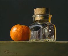 an orange sitting on top of a table next to a jar