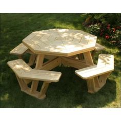 a wooden picnic table with benches in the grass