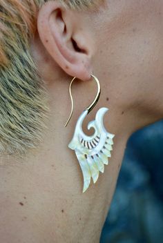 Handcrafted with love and intention, our exquisite Brass Feather Earrings are a testament to the beauty of nature and artistic craftsmanship. Each pair is meticulously created using ethically sourced Abalone shell and high-grade nickel-free brass. Inspired by the gentle curves and flowing forms found in nature, these stunning designs capture the essence of elegance and grace. The lightweight construction ensures a comfortable wear, allowing you to effortlessly elevate any outfit with a touch of unique sophistication. Whether you are embarking on a tranquil nature walk or dancing joyfully at a festival with friends, these beautiful earrings will be your statement piece, inspiring you to embrace your inner boldness. They are a reminder to celebrate your individuality and embrace the freedom Elegant Natural Drop Earrings, Natural Jewelry For Pierced Ears As A Gift, Natural Color Jewelry For Pierced Ears As A Gift, Natural Color Jewelry For Gifts With Pierced Ears, Elegant Wrap Earrings For Festivals, Traditional Shell Jewelry As Gift, Natural Shell Jewelry For Festivals, Handmade Shell Jewelry In Natural Color, Handmade Natural Shell Jewelry