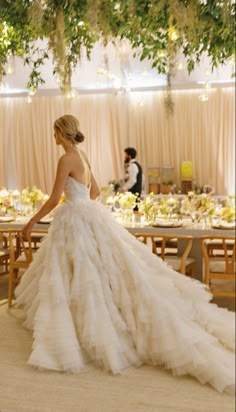 a woman in a wedding dress standing next to a table