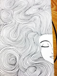 a drawing of a woman's face with wavy hair on top of a wooden table